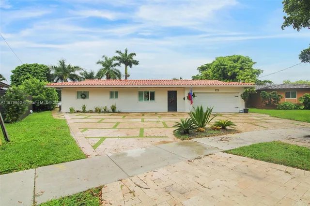 a view of a house with a yard and potted plants