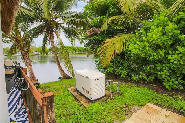 a view of a backyard with potted plants and large trees
