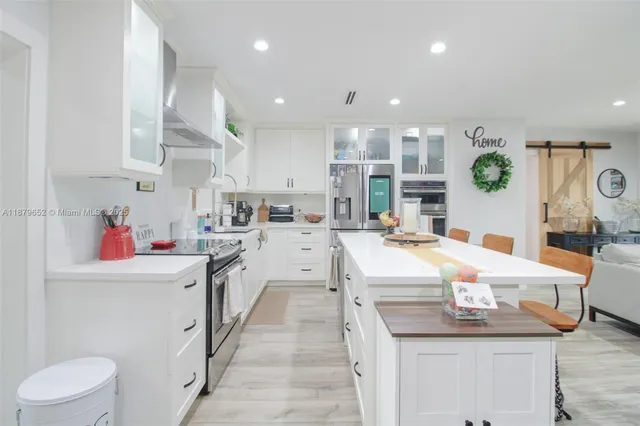 a kitchen with stainless steel appliances kitchen island granite countertop a sink and cabinets
