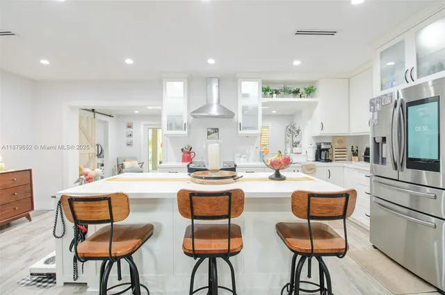 a kitchen with stainless steel appliances kitchen island a table and chairs in it