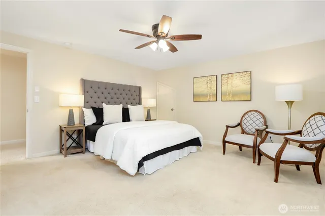 a bedroom with a bed a chair and painting on the wall