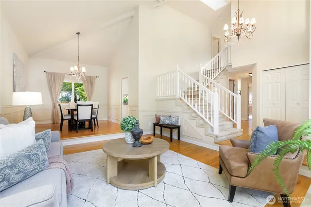 a living room with furniture a chandelier and a dining room