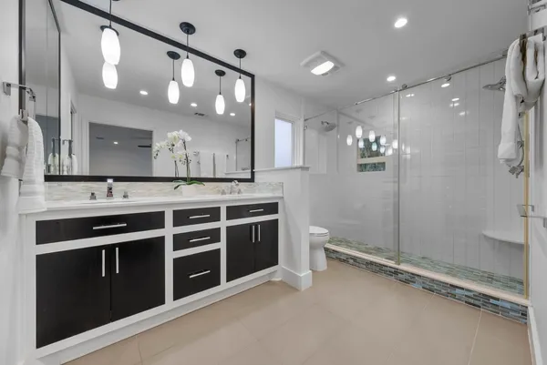 a bathroom with a sink a toilet and shower