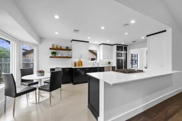 a kitchen with stainless steel appliances kitchen island granite countertop a sink and cabinets