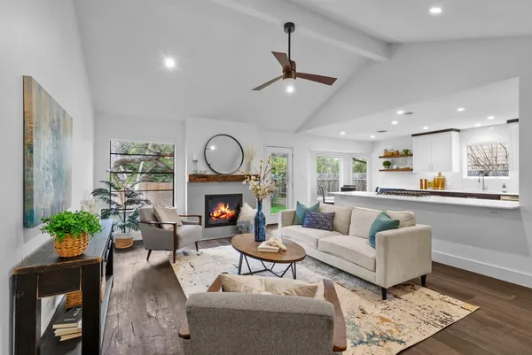 a living room with furniture a fireplace and a potted plant