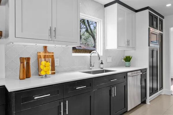 a kitchen with stainless steel appliances granite countertop a sink a counter space and cabinets