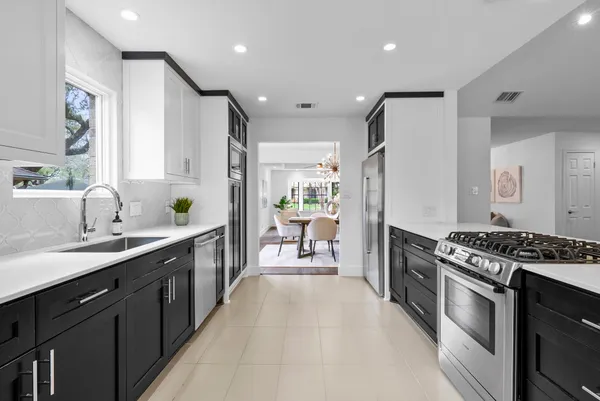 a kitchen with stainless steel appliances a sink stove and cabinets