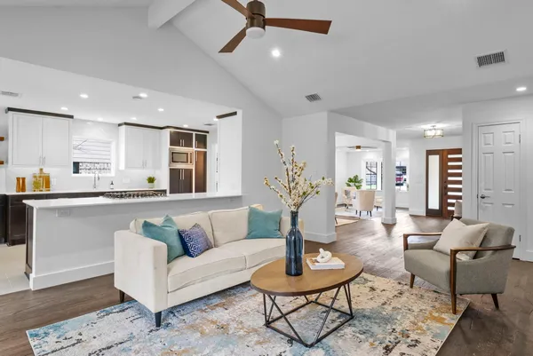 a living room with furniture kitchen view and a table
