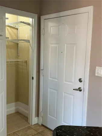 a view of an empty room with wooden floor and a ceiling fan