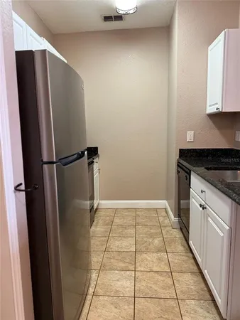 a kitchen with kitchen island a counter top space cabinets and stainless steel appliances