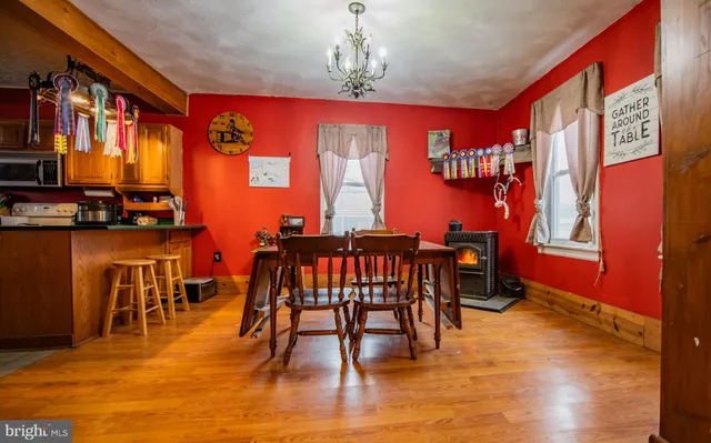 a dining room with furniture a chandelier and wooden floor