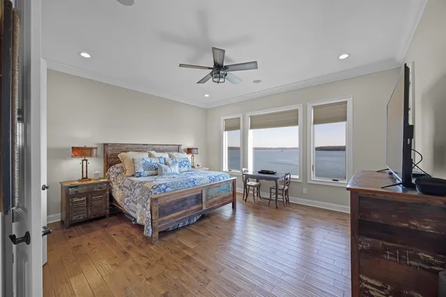 a bedroom with a bed large window and a flat tv screen