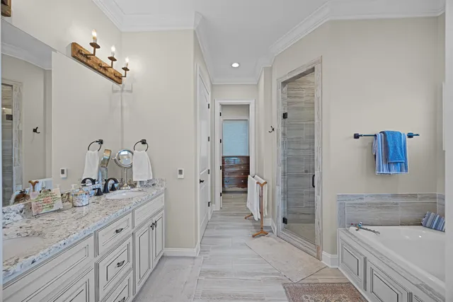 a spacious bathroom with a granite countertop sink mirror and a bathtub