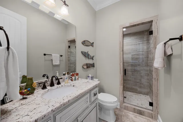 a bathroom with a granite countertop sink a toilet and shower