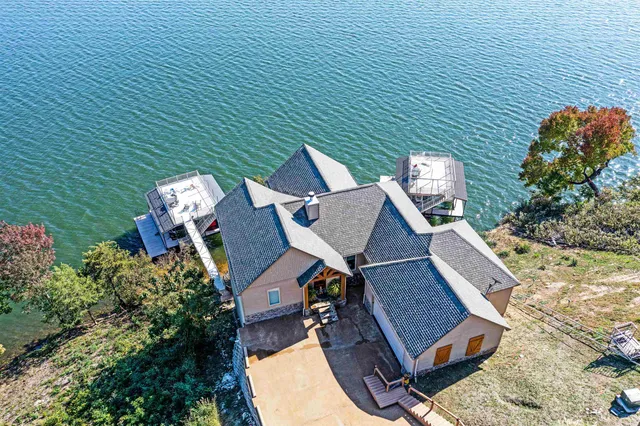 an aerial view of a house with swimming pool and patio