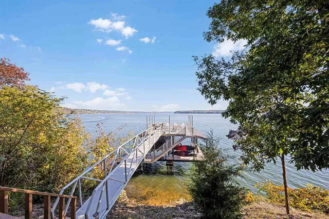 a view of a balcony with two plants and large trees