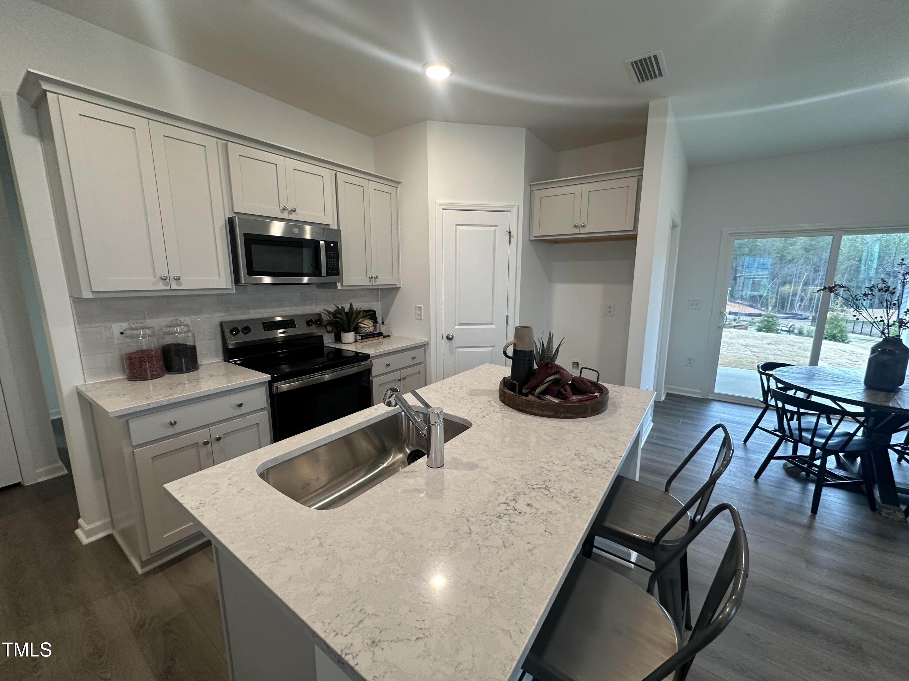 11198 Salers Loop Middlesex, NC 27557 - Photo 13 of 34 a kitchen with a stove a sink and a refrigerator