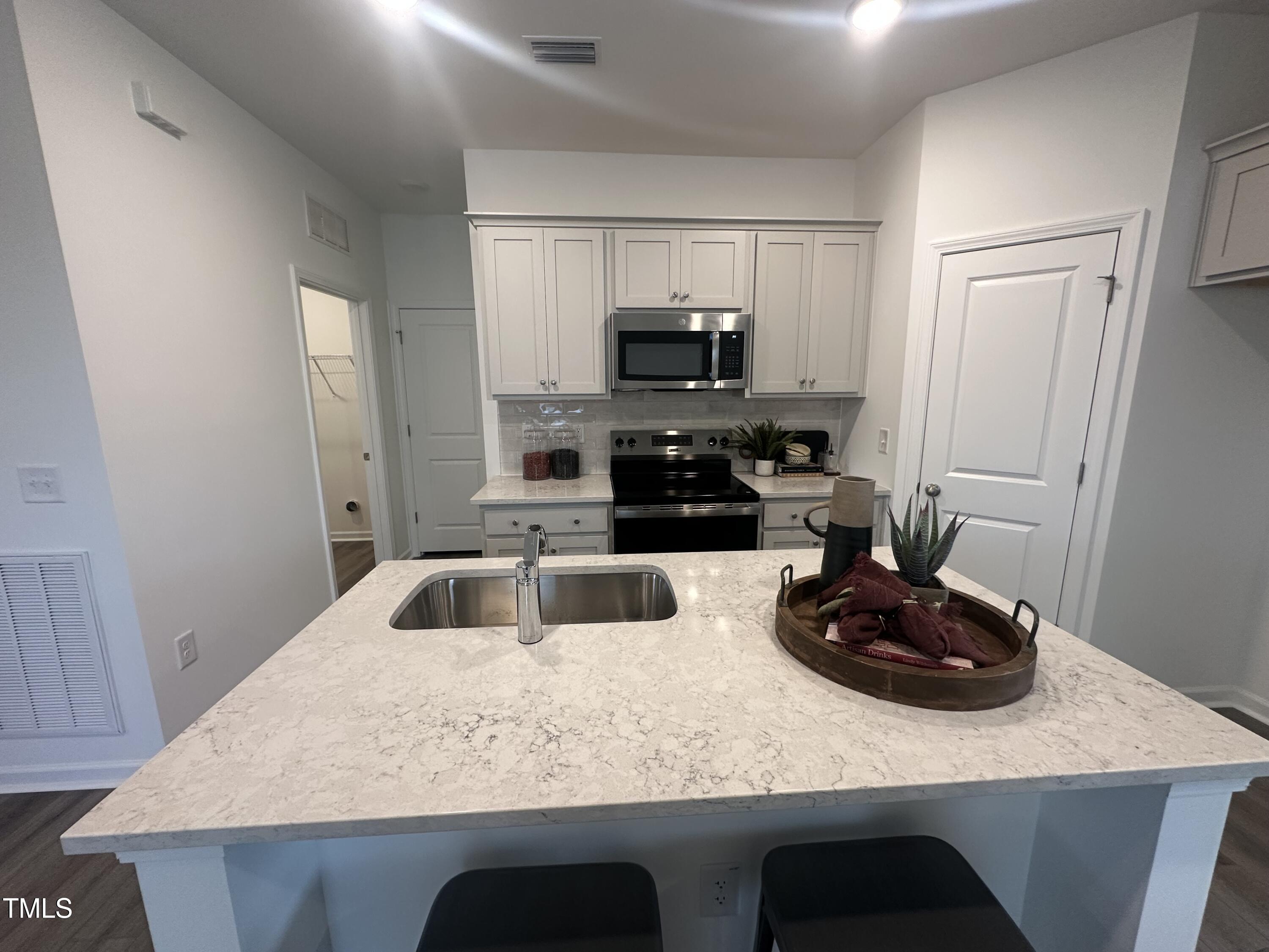 11198 Salers Loop Middlesex, NC 27557 - Photo 14 of 34 a kitchen with a sink a stove and cabinets