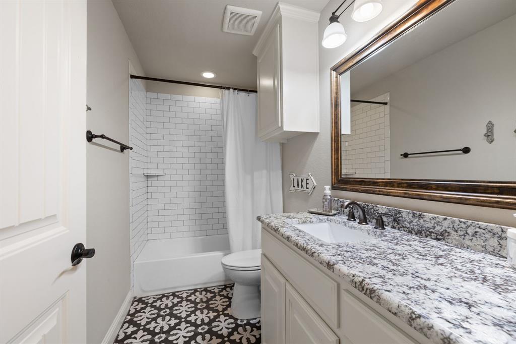 2103 Cash Point Court Granbury, TX 76049 - Photo 30 of 38 a bathroom with a granite countertop sink toilet and shower
