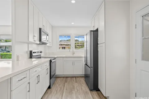 a kitchen with white cabinets and sink
