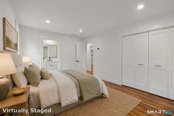 a spacious bedroom with a bed and a painting on the wall