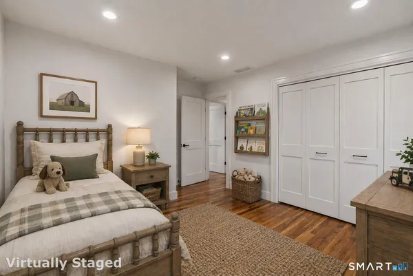 a bedroom with a bed and a lamp on dresser