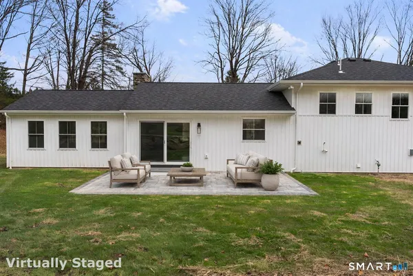 a backyard of a house with table and chairs