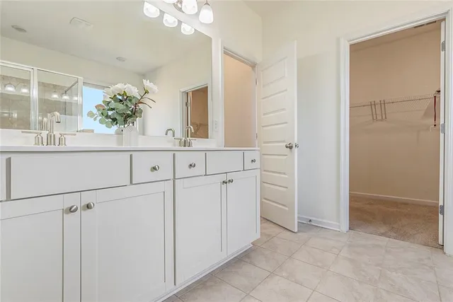 wooden floor with white cabinets and chandelier