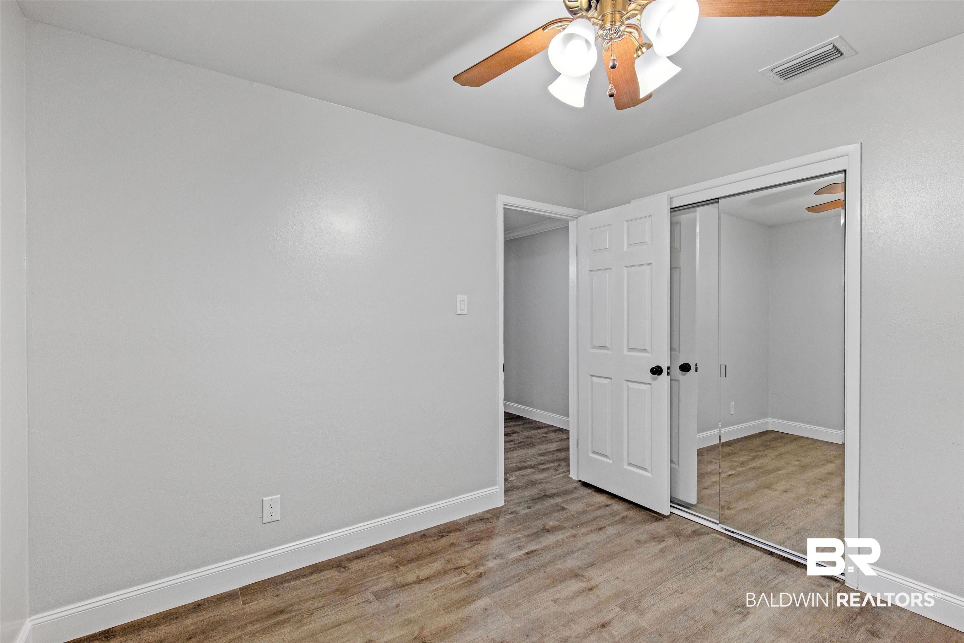 1432 South Polaris Drive Mobile, AL 36693 - Photo 12 of 27 Unfurnished bedroom featuring wood finished floors, a closet, and a ceiling fan