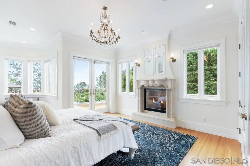 7971 Prospect Place La Jolla, CA 92037 - Photo 18 of 36 a spacious bedroom with a bed and a fireplace