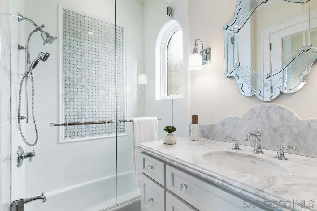 7971 Prospect Place La Jolla, CA 92037 - Photo 24 of 36 a bathroom with a granite countertop sink a mirror and shower