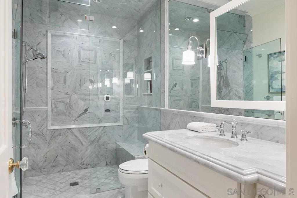 7971 Prospect Place La Jolla, CA 92037 - Photo 31 of 36 a bathroom with a granite countertop sink a toilet and shower