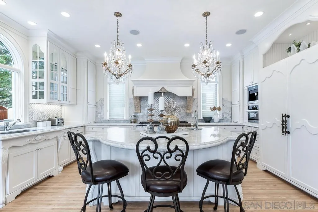 7971 Prospect Place La Jolla, CA 92037 - Photo 7 of 36 a view of a dining room with furniture a chandelier and wooden floor