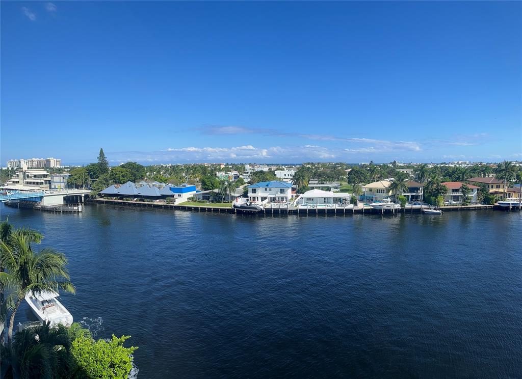 a view of a ocean with boats and trees in the background