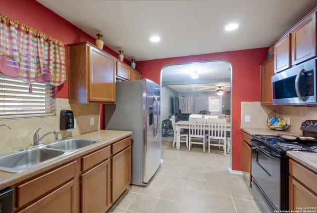 a kitchen with granite countertop a sink and a refrigerator
