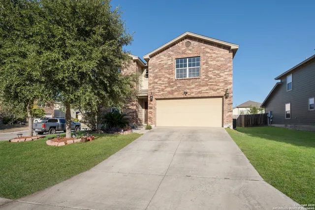 a front view of a house with garden and trees