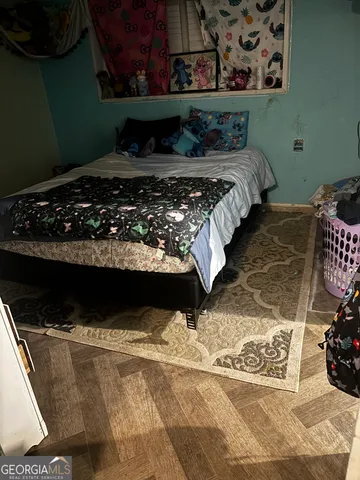 a bed sitting in a bedroom next to a window with cabinets
