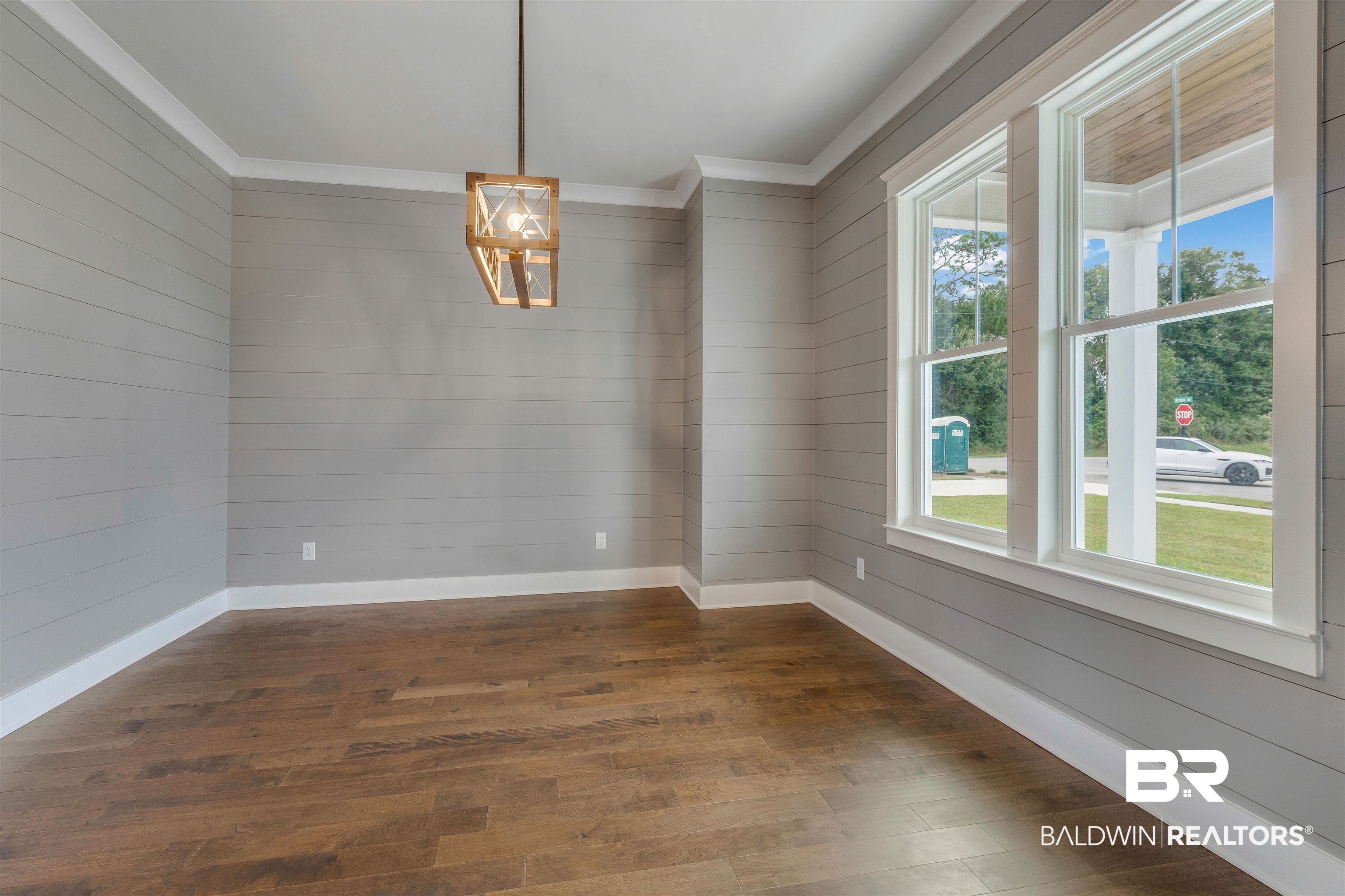 10985 Atrium Avenue Fairhope, AL 36532 - Photo 16 of 58 Unfurnished dining area featuring dark wood-type flooring, wood walls, a chandelier, and crown molding