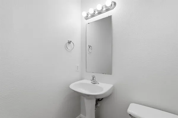 a bathroom with a sink a toilet and mirror