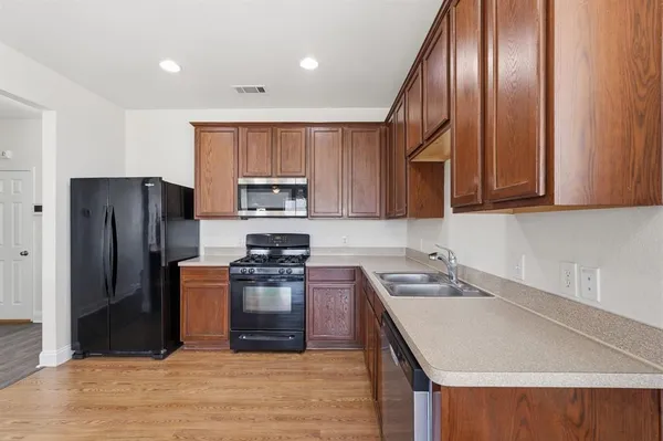 a kitchen with stainless steel appliances granite countertop a refrigerator sink and stove
