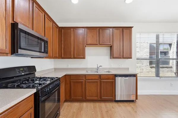 a kitchen with stainless steel appliances a sink stove and cabinets