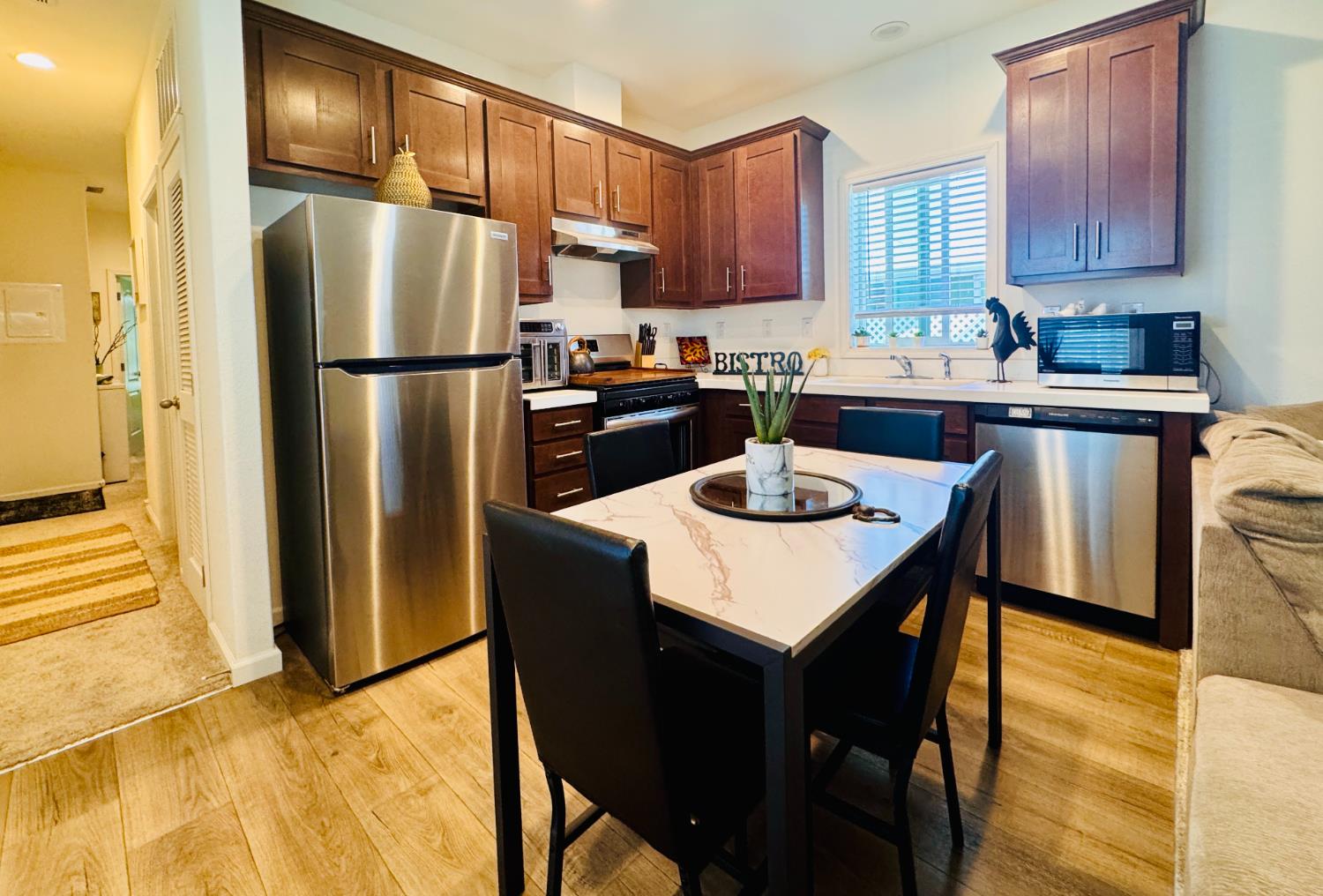 360 East Grant Line Road, Unit 16 Tracy, CA 95376 - Photo 2 of 36 Kitchen featuring wood-finish flooring, dark wood cabinetry, and stainless steel appliances