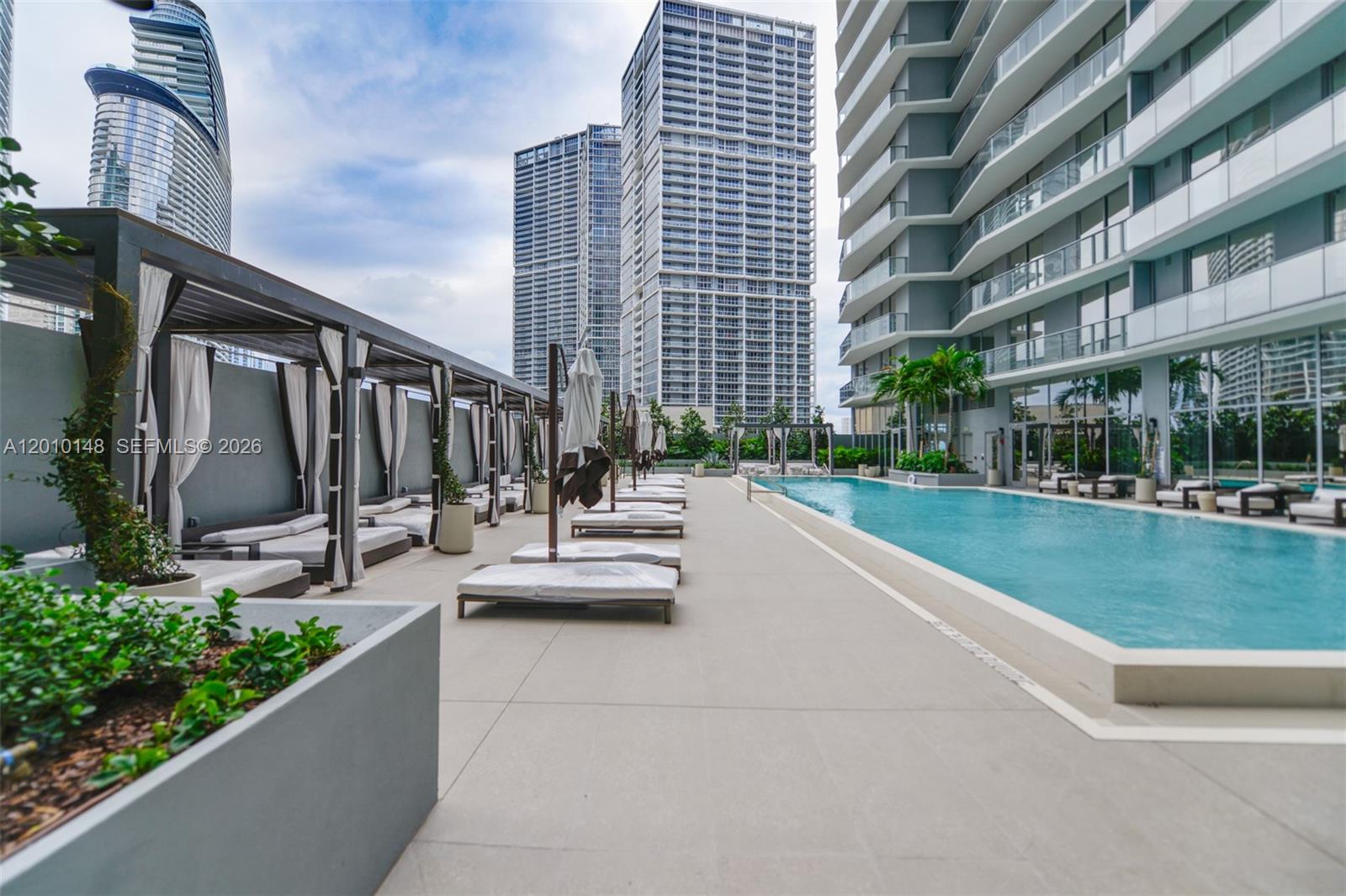 77 Southeast 5th Street, Unit 2604 Miami, FL 33131 - Photo 32 of 47 a view of swimming pool with outdoor seating and plants