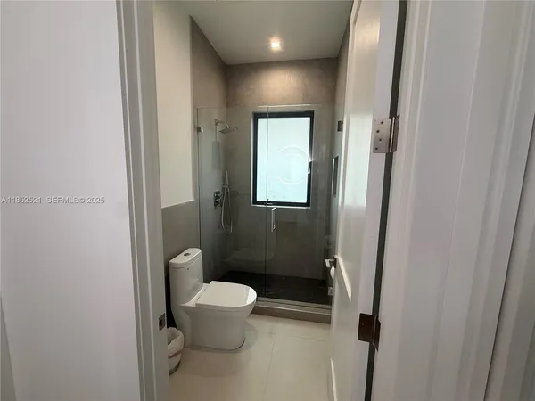 a spacious bedroom with a bed and a flat screen tv