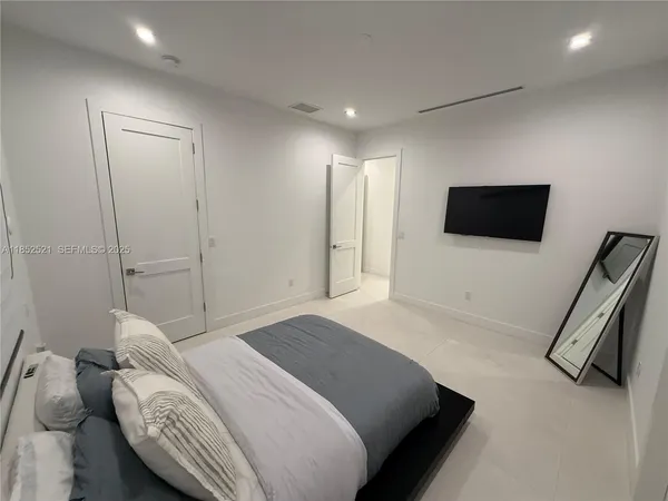 a bedroom with a bed and a flat screen tv