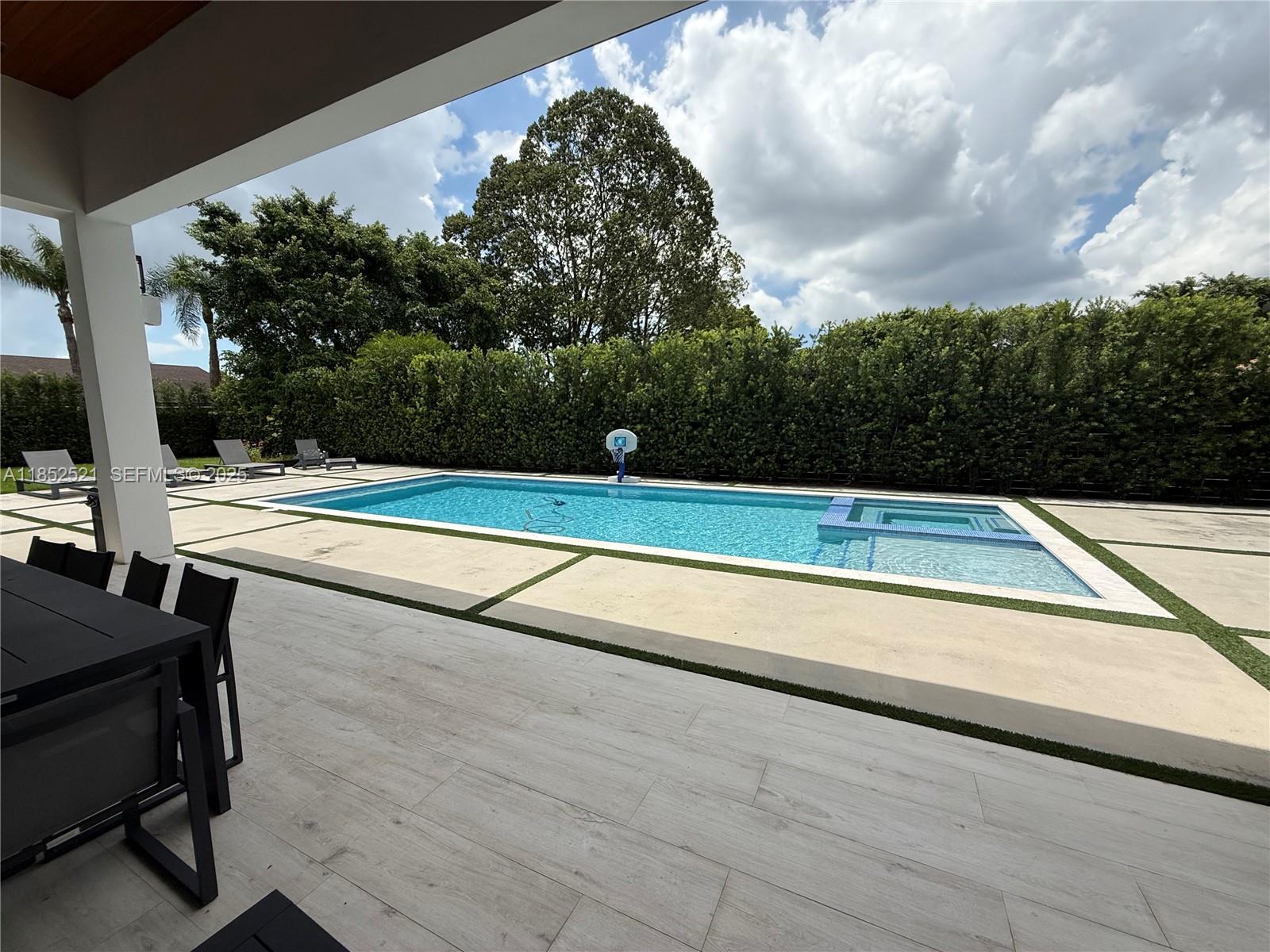 9600 Southwest 66th Street Miami, FL 33173 - Photo 49 of 56 a view of swimming pool with seating space and trees in the background