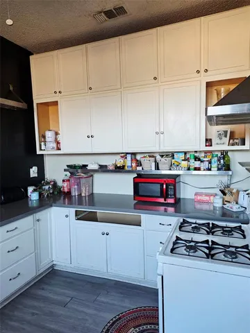 a kitchen with stainless steel appliances granite countertop a stove and a white cabinets