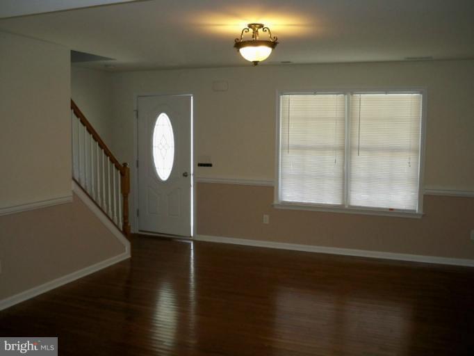 1458 Cox Neck Road Chester, MD 21619 - Photo 9 of 20 an empty room with wooden floor mirror and windows