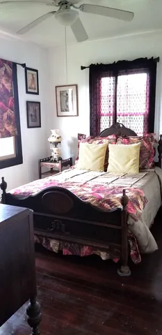 a bedroom with a bed wooden floor and window