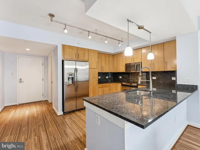 a kitchen with wooden floor window and refrigerator
